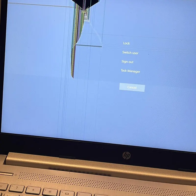HP laptop with a cracked screen photographed before screen replacement