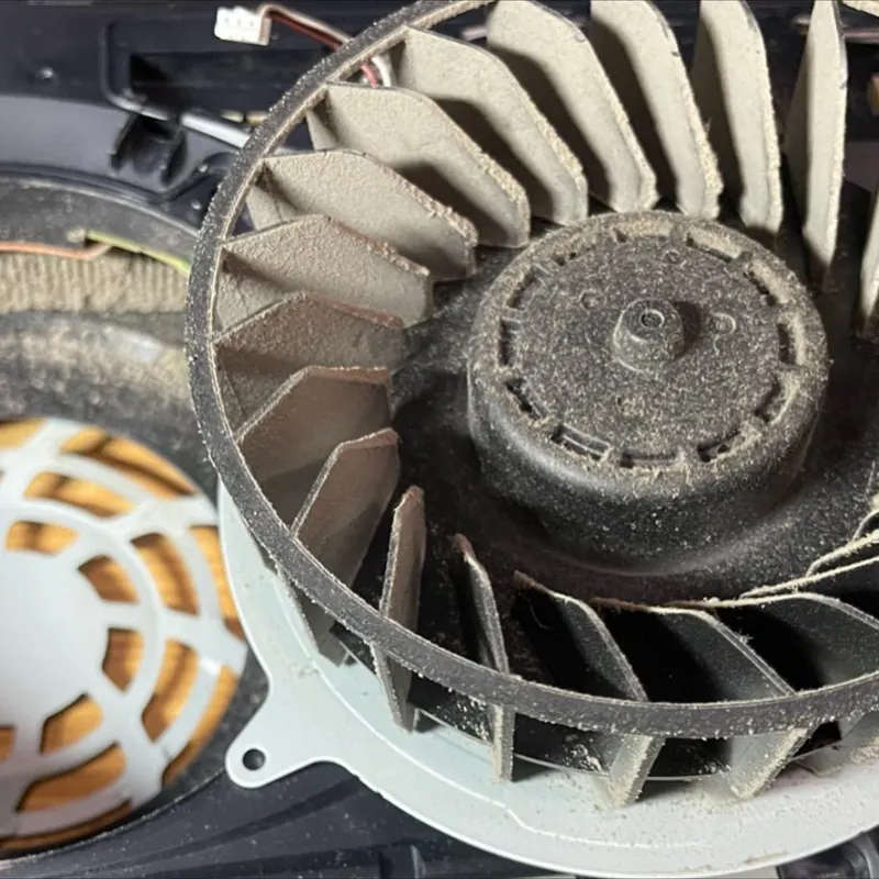 Dust-clogged PS5 cooling fan photographed before deep cleaning