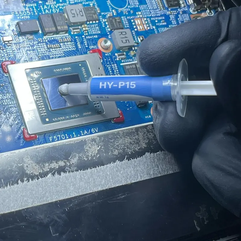 Applying fresh thermal paste to a laptop processor during service